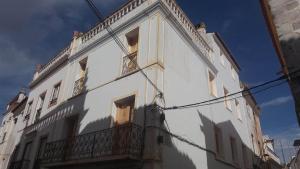 a white building with a balcony on the side of it at Flor da Laranjeira in Elvas