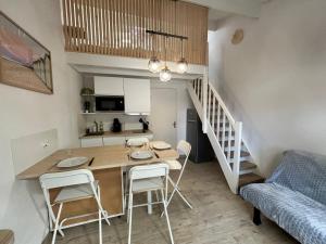 uma cozinha e sala de jantar com mesa e cadeiras em Magnifique Maison forêt & Mer avec piscine - Wifi em Saint-Jean-de-Monts