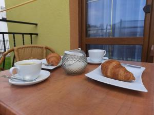 a table with two cups of coffee and croissants on it at Willa Lenka in Rewal
