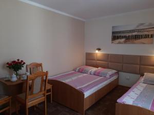 um quarto com 2 camas, uma mesa e uma cadeira em Willa Lenka em Rewal