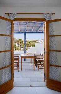 an open door to a patio with a table and chairs at fi naxos in Agios Prokopios