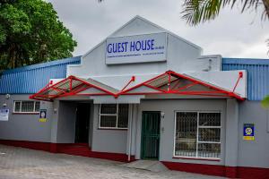 um edifício com uma placa que lê casa de hóspedes em 66 Anglers Rod Guesthouse em Richards Bay