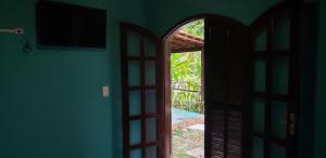 an open door to a room with a television at Chalés internacional l in Paraty