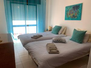 two twin beds in a room with a window at Olimar Sea View Apartment in Albufeira