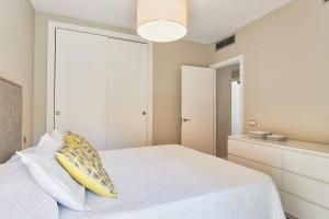 een slaapkamer met een wit bed en een geel kussen bij Deluxe la cala Alamar in La Cala de Mijas +22 foto's