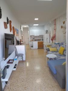 ein Wohnzimmer mit Couch und Küche in der Unterkunft Ancorà Angela - Playa del Inglès in Maspalomas