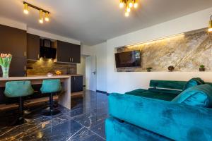sala de estar con sofá azul y cocina en Luxury Hedone Apartment near the Bridge with Private SPA Zone, en Zadar
