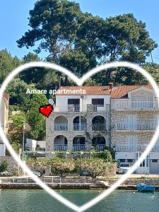 een hartvormig gebouw naast een waterlichaam bij Amare Apartments in Bobovišća