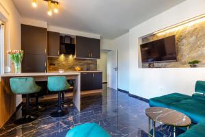 eine Küche und ein Wohnzimmer mit einem Tisch und Stühlen in der Unterkunft Luxury Hedone Apartment near the Bridge with Private SPA Zone in Zadar