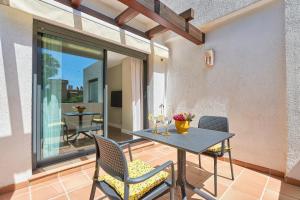 een patio met een tafel en stoelen en een balkon bij Deluxe la cala Alamar in La Cala de Mijas