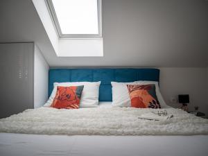um quarto com uma cama com uma cabeceira e almofadas azuis em Grand Amore Apartment em Dubrovnik