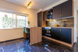 eine Küche mit schwarzen Schränken und einem Tisch darin in der Unterkunft Luxury Hedone Apartment near the Bridge with Private SPA Zone in Zadar