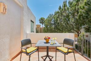 een terras met een tafel en stoelen op een balkon bij Deluxe la cala Alamar in La Cala de Mijas