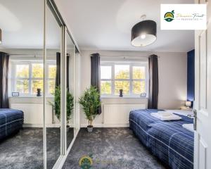 1 dormitorio con 2 camas y 2 ventanas en LOW rate this season for 3-Bedroom house In Bedworth - With Free Wi-fi, Private Parking & Garden by Passion Fruit Properties - OSB en Attleborough