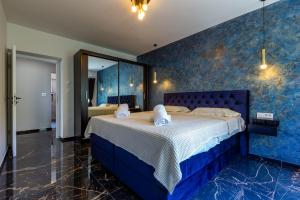 sypialnia z niebieskimi ścianami i dużym łóżkiem w obiekcie Luxury Hedone Apartment near the Bridge with Private SPA Zone w mieście Zadar