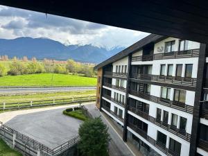an apartment building with a parking lot and mountains at Aspen Luxury Apartamnet in Razlog