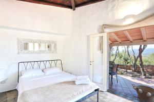 a bedroom with a bed and a large window at Volpe by DomusAway in Monte Petrosu