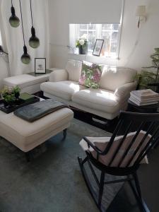 a living room with a white couch and a chair at Det Vita Huset in Stockholm