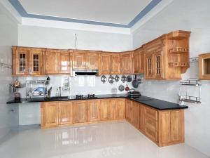 a kitchen with wooden cabinets and black counter top at Khách Sạn Toàn Uy - Đảo Phú Quý in Cu Lao Thu