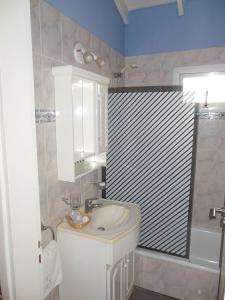 een badkamer met een witte wastafel en een douche bij Cabañas Valeria Kaupe in Valeria del Mar