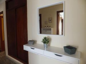 ein Bad mit einem Spiegel und einer weißen Kommode in der Unterkunft Magnífico piso céntrico in Isla Cristina