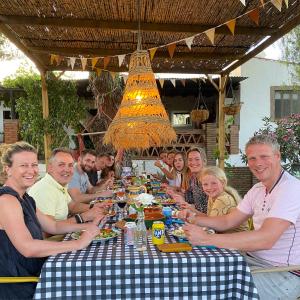 a group of people sitting around a long table at Glamping Bed and Breakfast Finca Alegria de la Vida in Pizarra