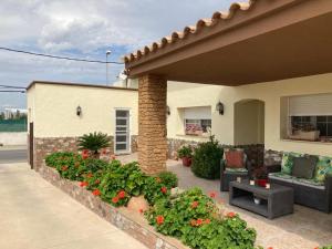 a house with a patio with flowers and plants at Casa Roseta in Deltebre