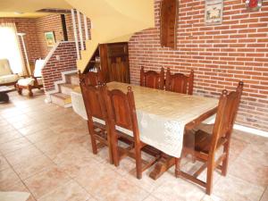 a dining room with a table and a brick wall at Cabañas Valeria Kaupe in Valeria del Mar