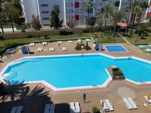 einen Blick über einen großen Pool mit Chaiselongues in der Unterkunft Ancorà Angela - Playa del Inglès in Maspalomas