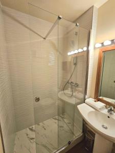 a bathroom with a shower and a sink at The Originals City, Hôtel Solana, Niort Est MendesFrance in Niort