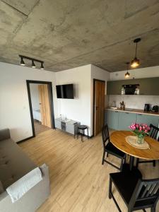 a living room with a table and a couch at Apartamenty Dębina 300m do plaży in Debina