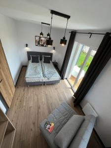 um pequeno quarto com uma cama e um sofá em Apartamenty Dębina em Debina