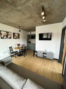 a living room with a couch and a table at Apartamenty Dębina 300m do plaży in Debina