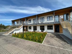 an apartment building with a patio and a courtyard at Apartamenty Dębina 300m do plaży in Debina
