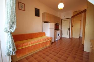 a kitchen with an orange couch and a refrigerator at Agenzia Vear Mare 23 in Lido delle Nazioni