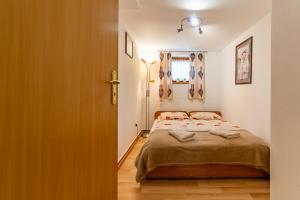 niewielka sypialnia z łóżkiem i oknem w obiekcie Willa Ela Cri w Zakopanem