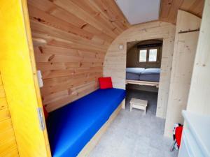a room in a tiny house with a blue bed at Holzhütte J24 Klein in Reichenau