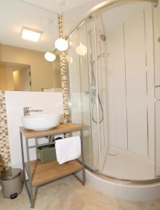 La salle de bains est pourvue d'une douche et d'un lavabo. dans l'établissement Falcon Apartment Center 3 Królewska, à Varsovie