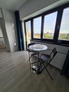 uma mesa e cadeiras num quarto com janelas em Global Residence Lake View em Bucareste