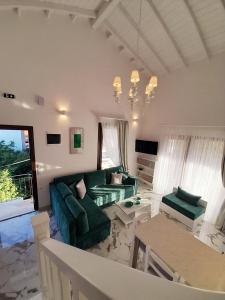 a living room with a green couch and a table at AGORA LUXURY LOFT in Ayios Nikolaos Sithonia