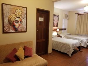 una habitación con 2 camas y una foto de una mujer en Apart-Hotel San Ignacio-Boutique 5 Estrellas, en San Ignacio de Velasco