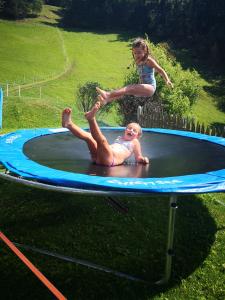 - deux enfants jouant sur un trampoline dans l'établissement Wieserhof Tirol, à Oetz