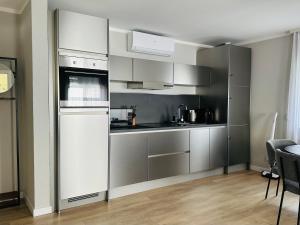 una cocina con armarios y electrodomésticos de acero inoxidable en Holiday Home Wiesbaden, en Wiesbaden