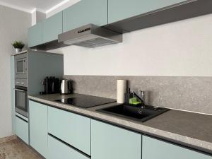 a kitchen with white cabinets and a sink at Holiday Home Wiesbaden in Wiesbaden +2 photos