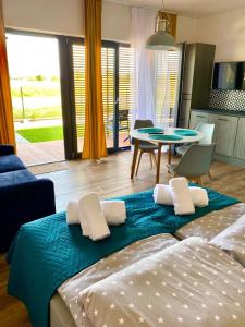 een woonkamer met 2 bedden en een eetkamer bij Apartamenty Czerwone Korale in Chłopy