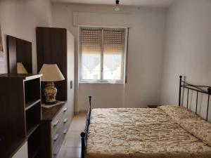 una camera con letto, cassettiera e finestra di Domus Olimpo a Guspini