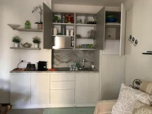 une cuisine avec des placards blancs et un comptoir dans l'établissement Buganvillea Cottage: un nido a 200 mt. dal mare, à Porto Pollo