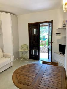 - un salon avec une table en bois dans l'établissement Buganvillea Cottage: un nido a 200 mt. dal mare, à Porto Pollo