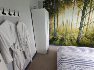 a room with a bedroom with a painting of a forest at Dan's House in Manchester