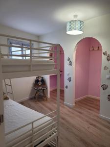 um quarto com 2 beliches e uma cadeira em Bonita casa adosada en esquina em Marbella